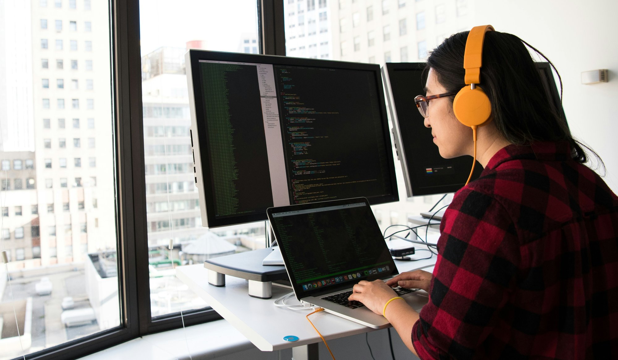 a woman with headphones on writing code