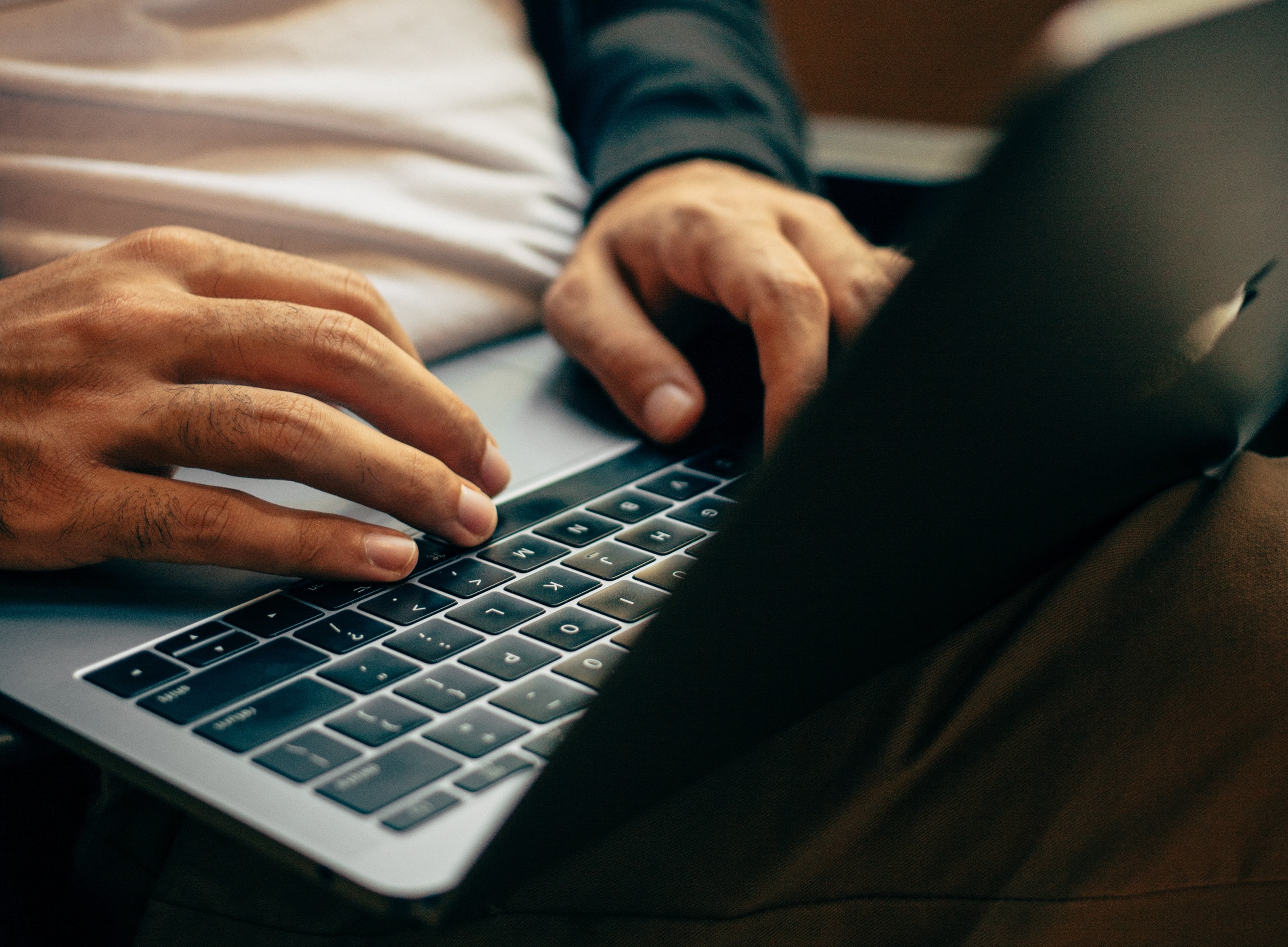 person with laptop on lap typing